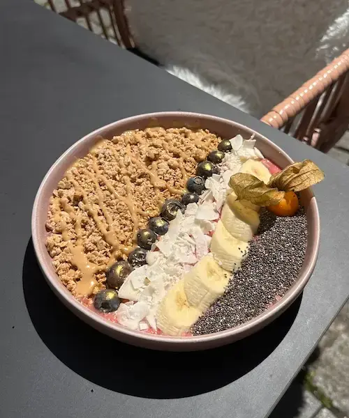 Beutau Bowl aus Erdbeer-Smoothie mit Granola, Banane, Blaubeeren, Kokoschips und Chiasamen