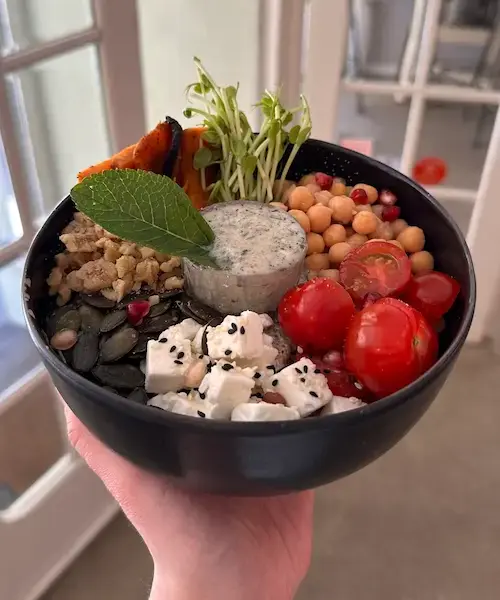 Mittelmeer Zauber mit Kichererbsen, Kirschtomaten, Feta, Kürbiskernen, gehackten Walnüssen, Granatapfelkernen, Süßkartoffel und veganem Minze-Joghurt-Dip